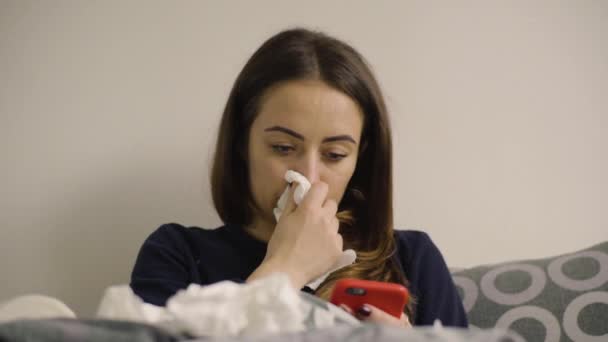 Mujer sonándose la nariz en su dormitorio — Vídeos de Stock