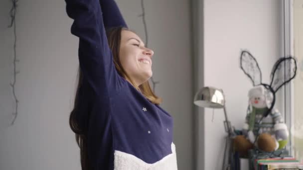 Happy woman in the morning stretching out looking out of the window — Stock Video