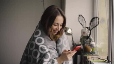 Cam kenarında Smartphone ayakta kullanan kadın güzel, paket