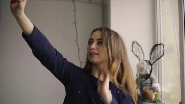 Lycklig kvinna tar selfie foto med mobiltelefon genom fönstret hemma — Stockvideo