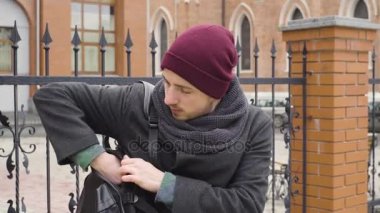 Genç bir adam şehrin kilisenin karşısında bir tablet kullanır