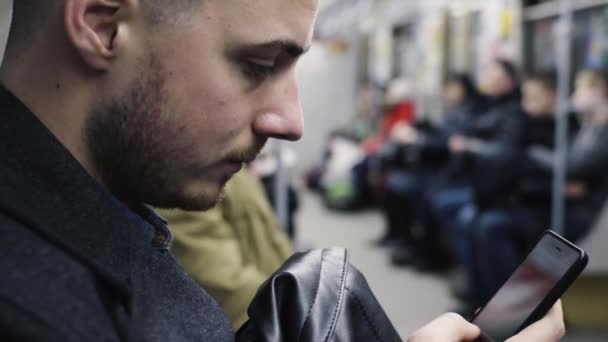 Anak muda menggunakan smartphone selama perjalanan metro — Stok Video