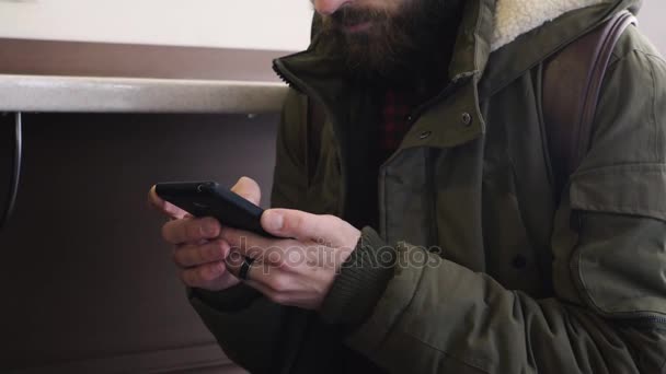 Mladý muž používá telefon v kavárně — Stock video