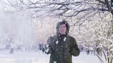 Kar daldan düşüyor. Bir adamın kafasını bir kukuleta ile kapsar. Ağır çekim.