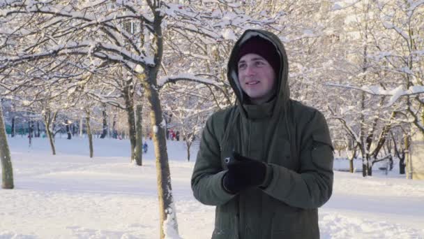 Giovane uomo giocare palle di neve nel parco 4K — Video Stock
