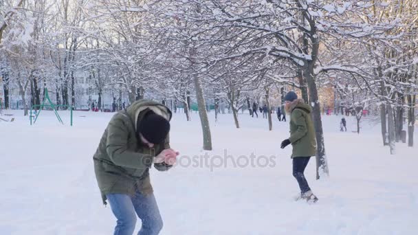 Junges Paar spielt Schneeballschlacht — Stockvideo