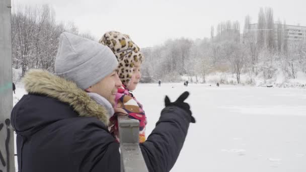 Far och dotter nära sjön på vintern — Stockvideo