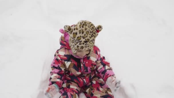 Little girl makes a snow angel — Stock Video