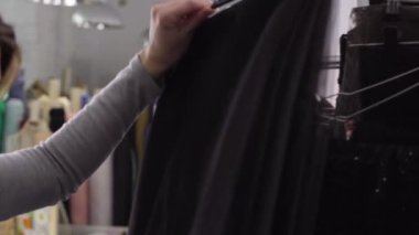 Genç bir kız için bir elbise bir ayna yakınındaki bir bez içinde atelier seçer.