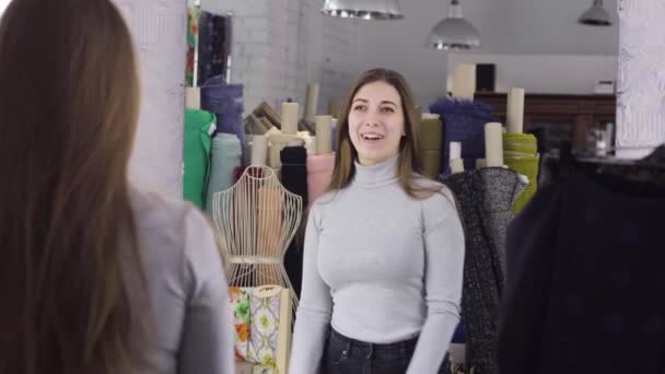 En ung flicka ser ut i spegeln i ateljén — Stockvideo