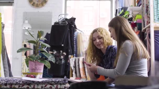Une jeune femme montre ses croquis et ses idées à un ami dans l'atelier — Video
