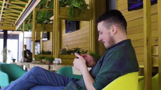 Gros plan de l'homme utilisant un smartphone dans un café — Video