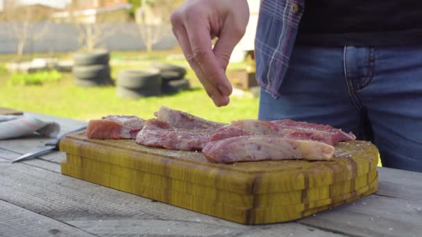 Mens mains sel et poivre la viande. Préparation d'un barbecue . — Video