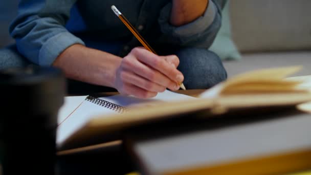 Joven toma notas mientras estudia en casa en la noche — Vídeos de Stock