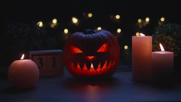 Calabazas de Halloween Jack-o-latern con velas en la mesa de madera — Vídeo de stock