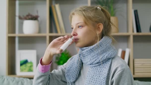 Женщина с лихорадкой и насморком использует носовой спрей — стоковое видео