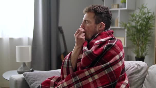 Ill man uses nasal spray on sofa in living room — Stock Video