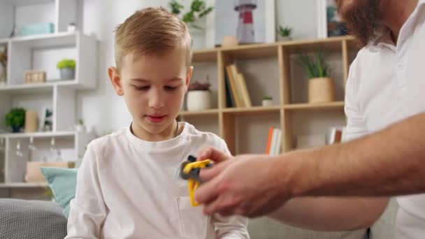 Father and son play with the constructor in the living room — Stock Video