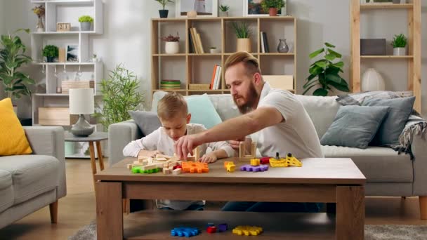 父亲和儿子在客厅里和建筑商玩耍 — 图库视频影像