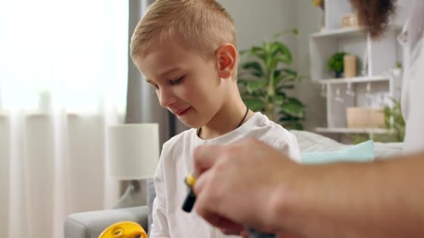 Far och son leker med en barndesigner i vardagsrummet — Stockvideo