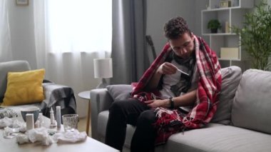 Hasta bir adam evdeki kanepenin sıcaklığını ölçüyor.