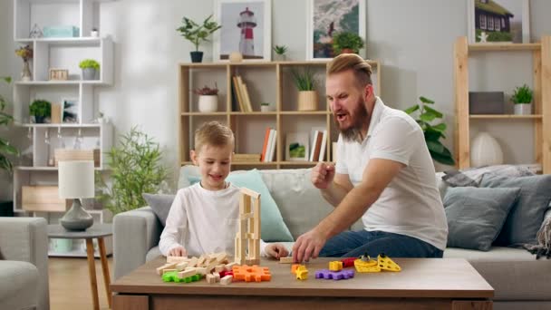 Père et fils jouent avec le constructeur dans le salon — Video