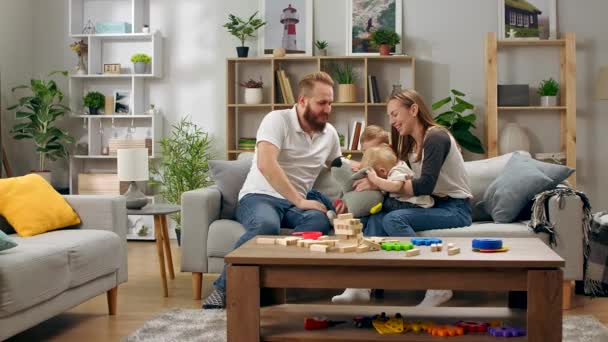 glückliche Familie spielt mit einem Spielzeugpinguin, der auf einem Sofa im Wohnzimmer sitzt