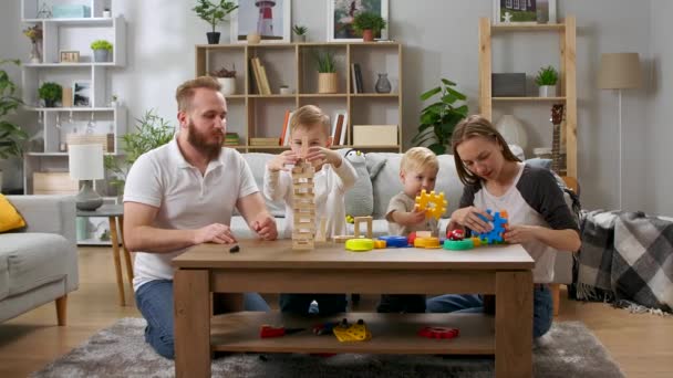 Familia feliz jugando con juguetes sobre la mesa en la sala de estar — Vídeos de Stock