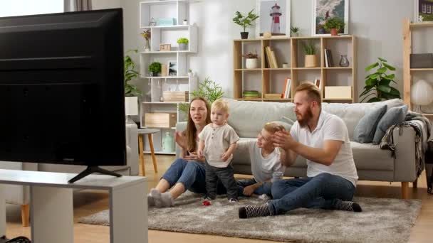 Família assistindo desenhos animados na TV e cantando músicas — Vídeo de Stock