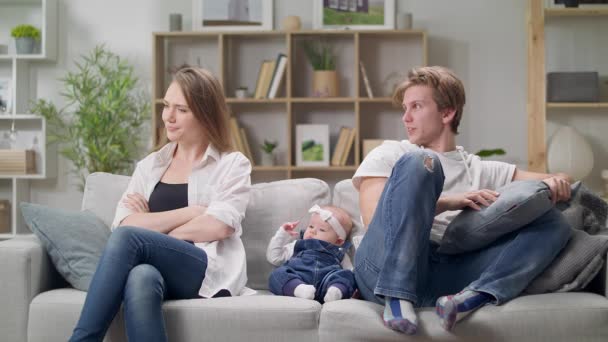 Mom and dad quarrel sitting on a sofa in the presence of a small daughter — Stock Video