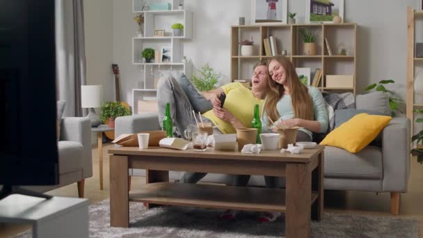 Ten chlap a ta holka leží na gauči po nenasytnosti v obýváku. — Stock video