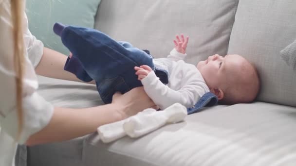 Mom changes diapers for little daughter in the morning in the sun — Stock Video