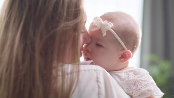 Mutter küsst und umarmt eine kleine Tochter in der Morgensonne — Stockvideo