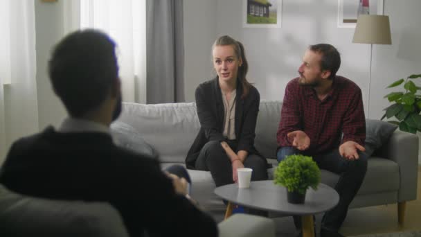 Junges Paar im Büro eines Familienpsychoanalytikers. Der Mann ist ratlos. — Stockvideo