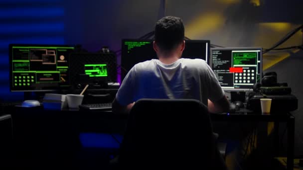 Caucasiano jovem espião virtual masculino hackear algum software à noite no quarto escuro — Vídeo de Stock