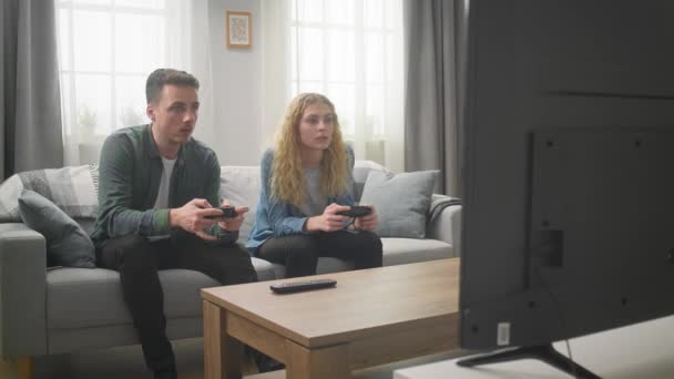 Amigos alegres jogando videogames em casa, a mulher está ganhando o jogo — Vídeo de Stock