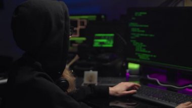 Koyu başlıklı Hacker Girl, karanlık bir odada veri koduyla çalışan programcı..