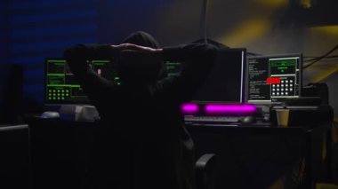 Hacker karanlık bir odada veri koduyla çalışırken dinleniyor. Bilgisayar korsanları masası.