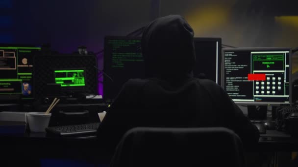 어두운 후드를 쓰고 어두운 방에서 컴퓨터를 공격하는 십 대 해커 소녀 — 비디오