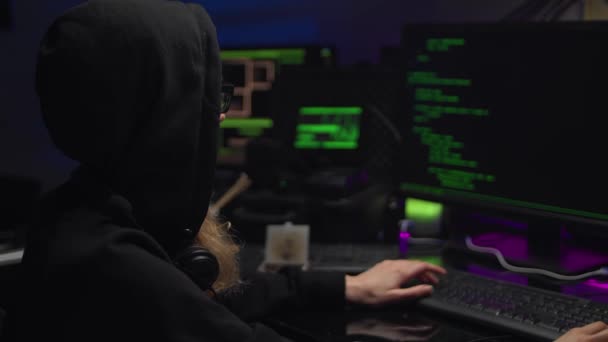Hacker Girl in dark hood, programátor pracující s datovým kódem v tmavé místnosti. — Stock video
