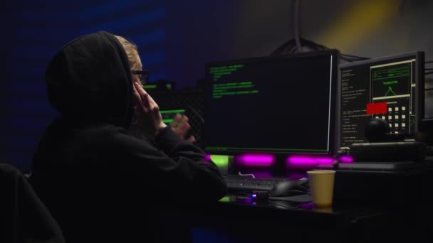 Mujer hacker en una capucha oscura hablando en un teléfono inteligente — Vídeo de stock
