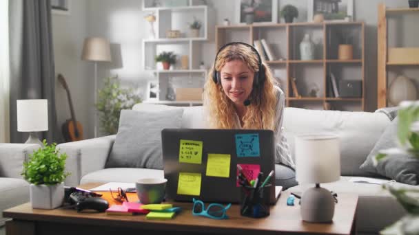 Young woman wears headset conference calling on laptop talks with online teacher studying, working from home. — Stock Video