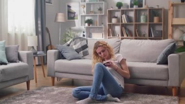 Hiperlapse, genç bir kadın oturma odasındaki telefonu çeşitli pozlarda kullanıyor..