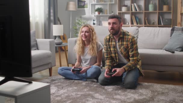 Férfi és nő videojátékozik otthon a nappaliban — Stock videók