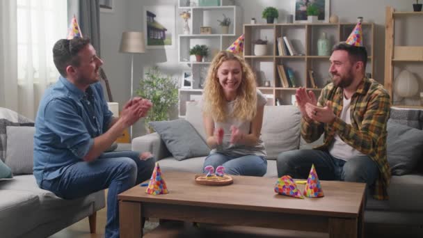 Three friends celebrate a birthday. Blowing out the candles. — Stock Video