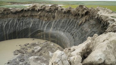 YAMAL PENINSULA, RUSSIA - JUNE 18, 2015: Expedition to the giant funnel of unknown origin. Crater view. clipart
