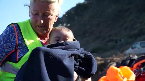 Lesbos, Grecia. Noviembre 2015. Volonteer ayuda a niño refugiado . — Vídeo de stock