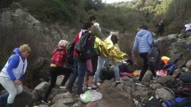Lesbos, Řecko - 5. listopadu 2015: Dobrovolníci pomáhají uprchlíkům na břehu. — Stock video