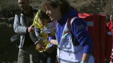 Lesvos, Yunanistan - 5 Kasım 2015: sahile gitmek için gönüllü yardım mülteci.