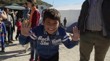 Lesvos, Yunanistan - 5 Kasım 2015: kamera'mülteci kampındaki gülüp Suriye çocuk.